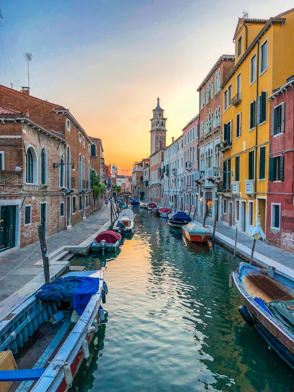 Venice canal with gondola at sunset, Italy